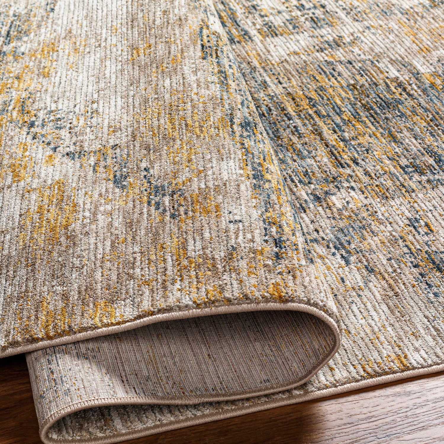 Close-up of the Cadao Rich Textured Traditional Rug showing light peach, mocha, brown, and taupe colors. Fold
