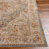 Close-up of the textured Cress Tan Rich Traditional Rug with bone, blue, and rust colors on a wood floor. Front