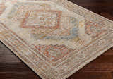Close up of the Moya Tan rug showing its rich texture, traditional pattern, and colors like bone, clay, and brown. Corner