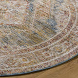 Close-up of the round Moya Tan rug. Rich texture with bone, clay, blue, and brown tones. Traditional style. Texture