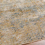 Close-up of the Sava Tan Rich Textured Rug, showing bone, brown, and blue tones with a subtle, contemporary pattern. Texture