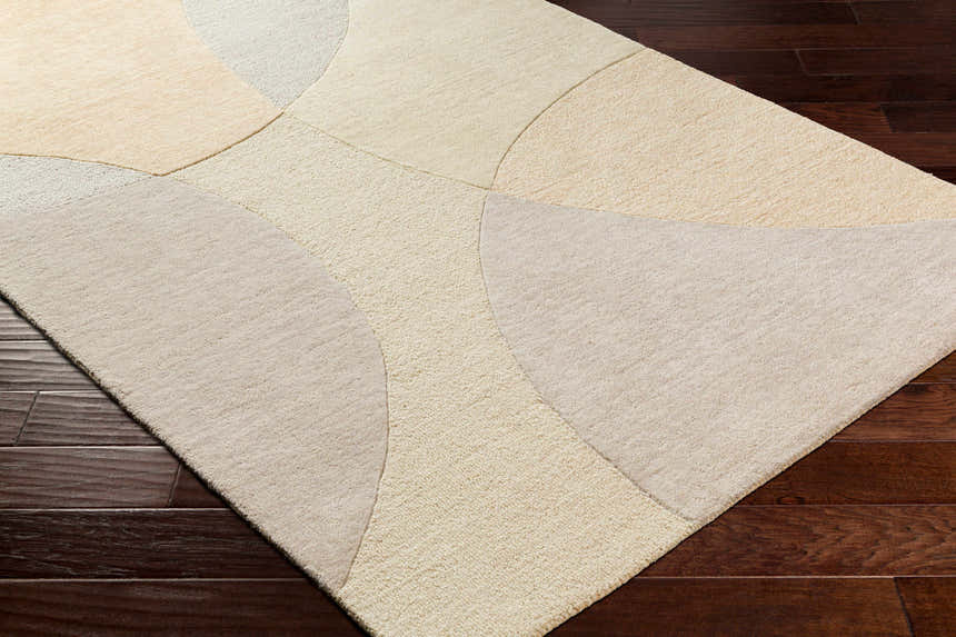 Close up of Cassiopeia Light Brown & Beige Area Rug showing geometric pattern and soft wool texture on dark wood floor. Corner