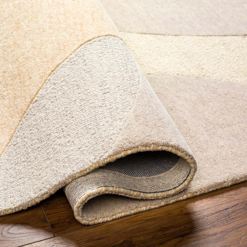 Close up of the hand-tufted Cassiopeia Light Brown & Beige Area Rug showing wool texture and backing. Fold