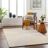 Living room scene with Cassiopeia Light Brown & Beige Area Rug, gray chair, wood side table, and plants. Contemporary style. Roomscene-Rectangle