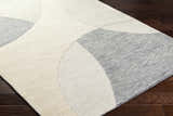 Close-up of the hand-tufted Cassiopeia Gray & Beige Area Rug showing its contemporary geometric design and wool texture. Corner