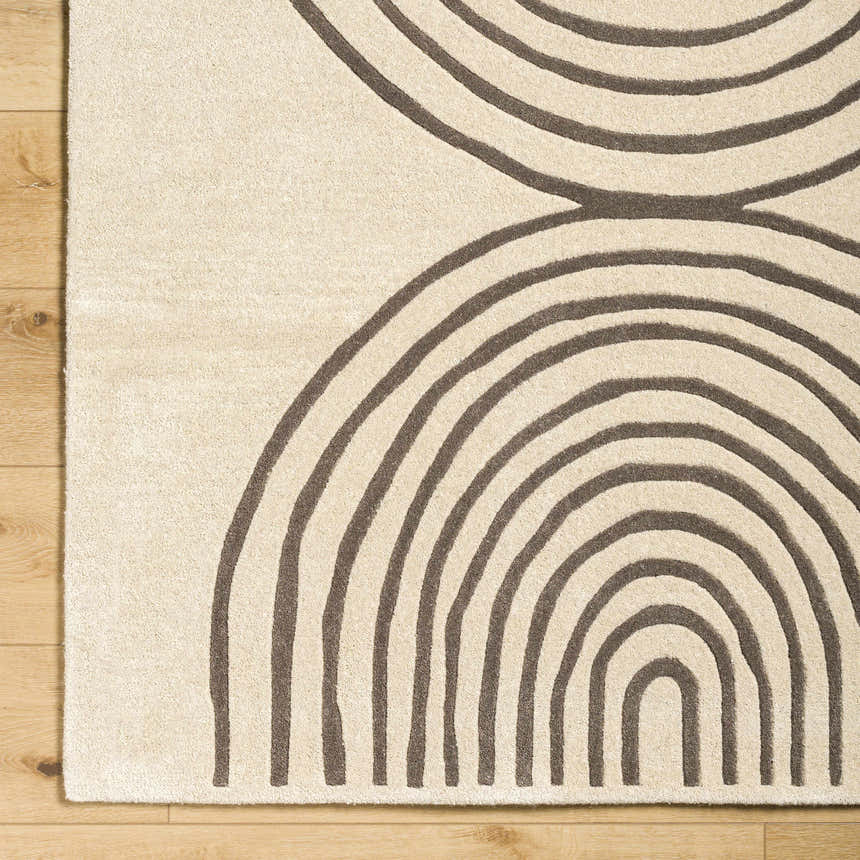 Close-up of Fuat Beige Area Rug showing its hand-tufted texture and contemporary brick red and pearl arch pattern. Corner