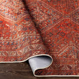 Close-up of the Siocon Washable Area Rug. Features a traditional, farmhouse design with red, blue, and white colors. Fold