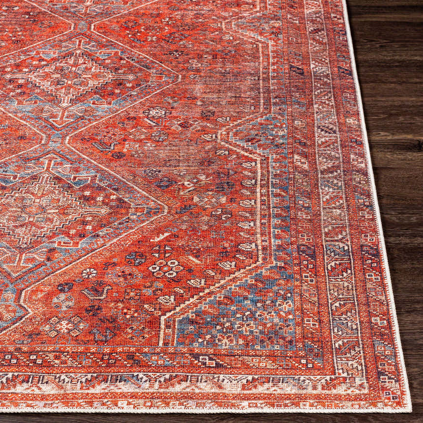 Close-up of the Siocon Washable Area Rug. Features a traditional, farmhouse design in red, blue, and white tones. Front