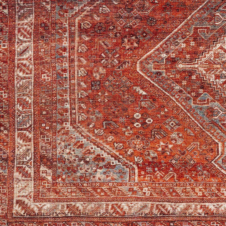 Close-up of the Siocon Washable Area Rug showing its traditional, intricate pattern and rich red, blue, and cream colors. Swatch
