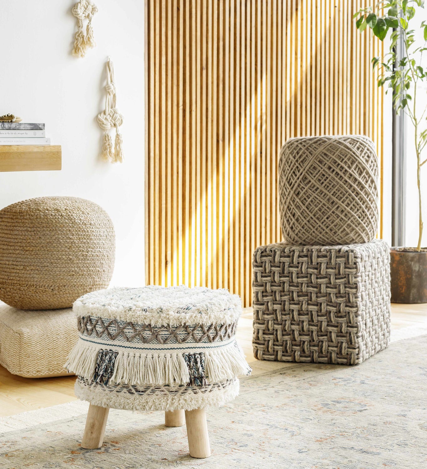 Bohemian living room scene with the Sipocot Premium Area Rug, poufs, and woven accents. Styleshot