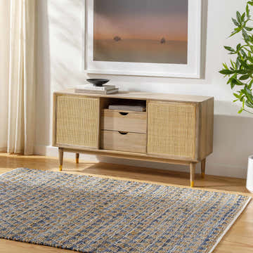 Living room scene with a Colm Recycled Blue Jean Rug, woven texture, blue and tan colors, under a wood and cane console table. Roomscene-Rectangle
