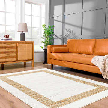 Living room scene with Ghita White Area Rug, tan leather sofa, wood cabinet, and gray accent wall. Roomscene-Rectangle