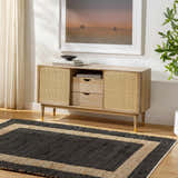Living room scene with a Ghita Black Area Rug under a light wood cabinet with woven rattan doors. Roomscene-Rectangle
