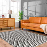 Living room scene with orange sofa and black and white Gzifa Jute Rug. Contemporary style. Roomscene-Rectangle