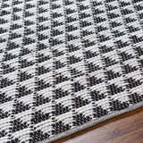 Close-up of the hand-woven Gzifa Jute Rug; a contemporary rug with a black and white geometric pattern. Texture