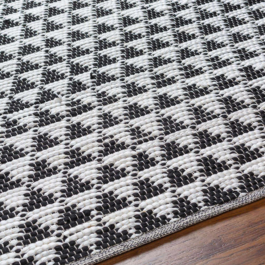 Close-up of the hand-woven Gzifa Jute Rug; a contemporary rug with a black and white geometric pattern. Texture