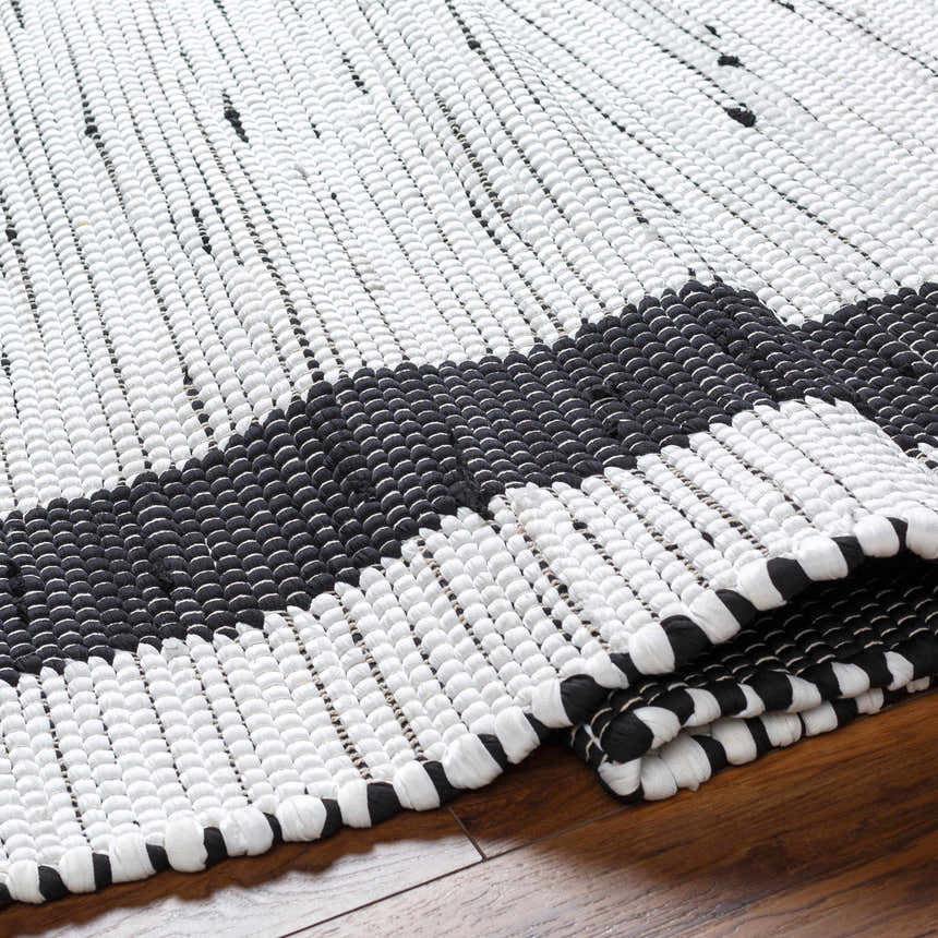 Close-up of the hand woven Jaden Area Rug. Charcoal and off white recycled fabric with a contemporary design. Fold