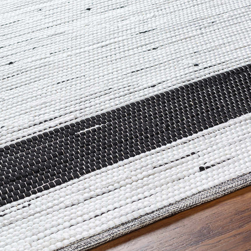 Close-up of the hand woven Jaden Area Rug. Charcoal and off white jute and recycled fabric blend. Contemporary style. Texture