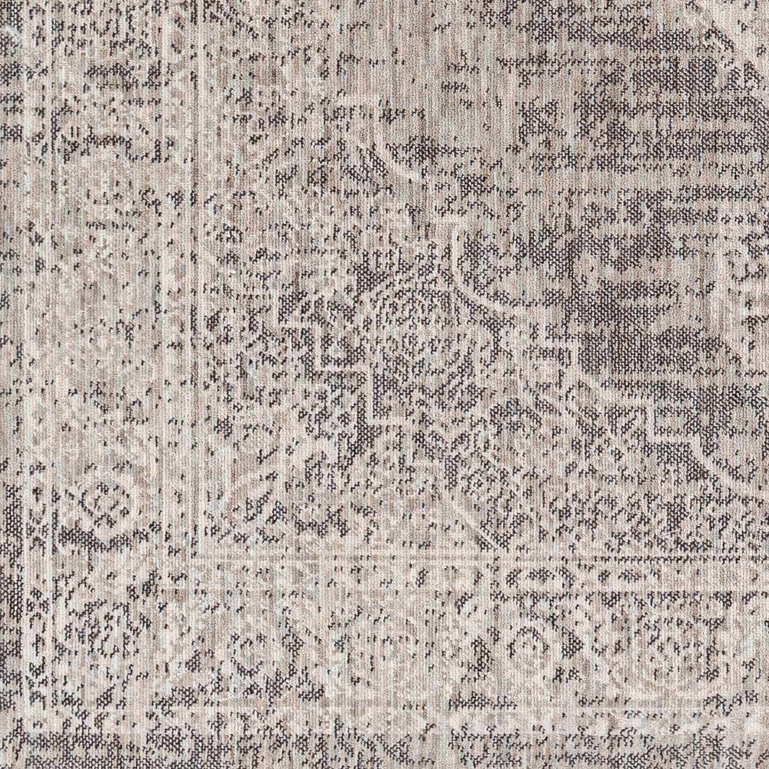 Close-up of the Azibo Area Rug showing its traditional pattern and texture in black, gray, taupe and brown tones. Swatch