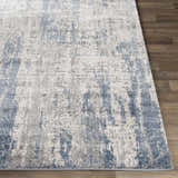 Close-up of Skidby Area Rug. Blue, charcoal, and gray abstract pattern on an off-white base. Contemporary style. Front