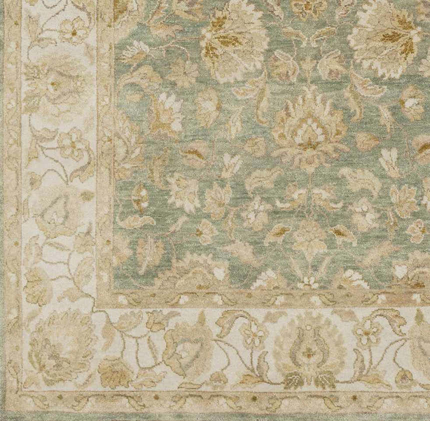 Close-up of the hand-knotted Skipwith Area Carpet. Features a traditional floral design in sage green and cream tones. Swatch