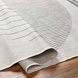 Close-up of the Aviya Light Gray Area Rug showing its light gray, off-white, and medium gray geometric pattern and woven texture. Fold