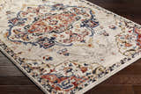 Close-up of the Karah Area Rug, a beige and bone traditional rug with red and blue floral accents. Corner