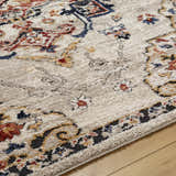 Close-up of the Karah Area Rug showing a traditional beige and bone floral pattern with red and blue accents. Texture