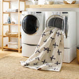 Laundry room scene with the beige Bede Washable Area Rug in the dryer, showcasing its easy-to-clean feature. Washing-Machine