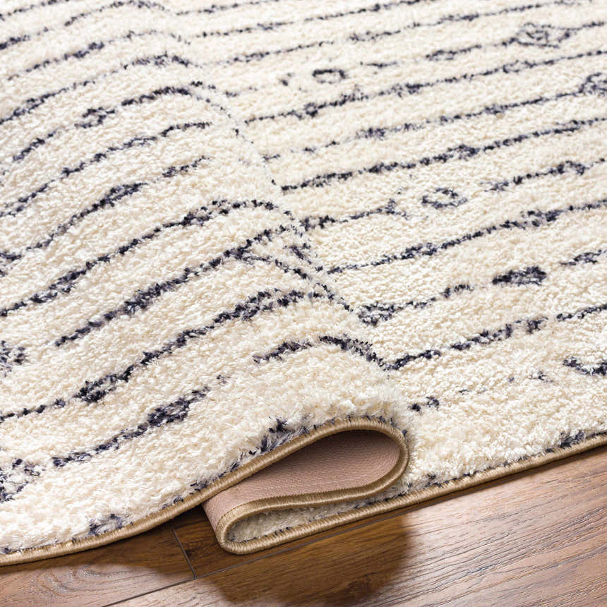 Close up of the Demi Beige Washable Area Rug showing its plush texture and modern striped design. Fold
