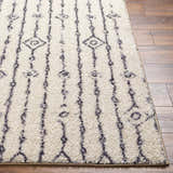 Close-up of the Demi Beige Washable Area Rug. Features a shag texture and a vertical geometric pattern. Front