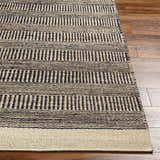 Close-up of the Black Elle Area Rug showing its hand-woven jute texture and geometric black and beige stripes. Front