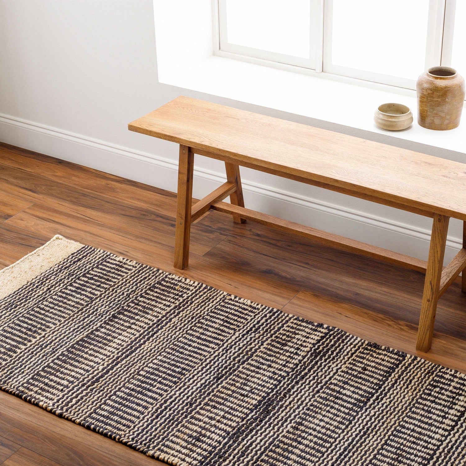 Entryway with wood bench and Black Elle Area Rug, a black and beige jute runner with geometric pattern. Roomscene-Runner