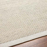 Close-up of the hand-woven Cream Emlen Area Rug showing the neutral color, textured wool, and subtle pattern. Texture