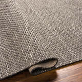 Close-up of the hand woven Emlen Nutmeg Area Rug showing its beige, brown, and bone textured wool design. Fold