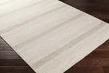 Close-up of the hand woven Silverthorne Wool Area Rug. Cream and medium gray stripes and geometric pattern. Corner