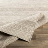 Close-up of the Silverthorne Wool Area Rug. Cream and gray rug with a textured, hand-woven design on wood floor. Fold
