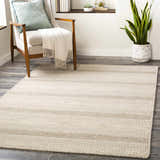 Living room scene with a Silverthorne wool area rug, chair with throw, and snake plant. Cream and gray tones. Roomscene-Rectangle