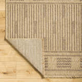 Close-up of the Gerik Faux Jute Rug showing its lambswool and light brown colors, vertical stripes, and geometric pattern. Fold