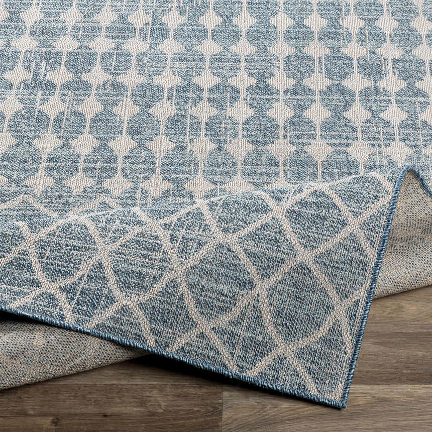 Close up of Blue Ivory Summit Indoor Outdoor Rug showing geometric pattern and texture. Fold
