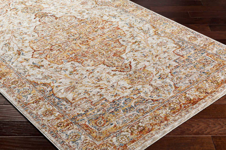 Close-up of the Aman Beige Area Rug showing its traditional design, brick red, navy, and mustard colors on dark wood floors. Corner