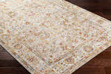 Close-up of the Duong Beige Textured Rug with Fringes, featuring a traditional floral pattern in brick red, mustard, and blue. Corner
