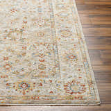 Close-up of the Duong Beige Textured Rug showing its traditional floral pattern and brick red, blue, and mustard colors. Front
