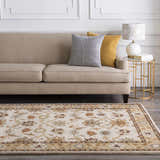 Living room scene with a beige sofa and the floral, traditional Smoot Area Rug in brown, beige, and blue. Roomscene-Rectangle