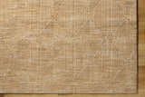 Close up of the Dekan Tan Area Rug featuring a geometric diamond pattern and textured lambswool color. Corner