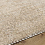 Close-up of the Dekan Tan Area Rug showing its subtle herringbone pattern and soft lambswool and light brown colors. Texture