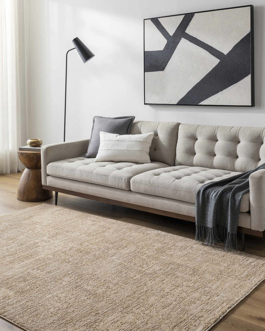 Living room scene with a tan sofa and the Kahua Tan Area Rug adding warmth to the space. Roomscene-Rectangle