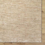 Close-up of the tan Kahua Area Rug showing its subtle horizontal pattern and texture on light wood flooring. Corner
