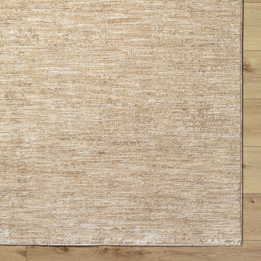 Close-up of the tan Kahua Area Rug showing its subtle horizontal pattern and texture on light wood flooring. Corner