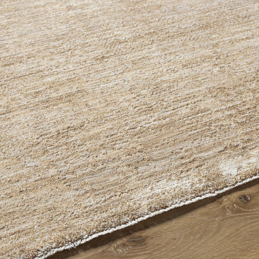 Close-up of the textured Kahua Tan Area Rug on hardwood floor. Neutral color, machine woven. Texture
